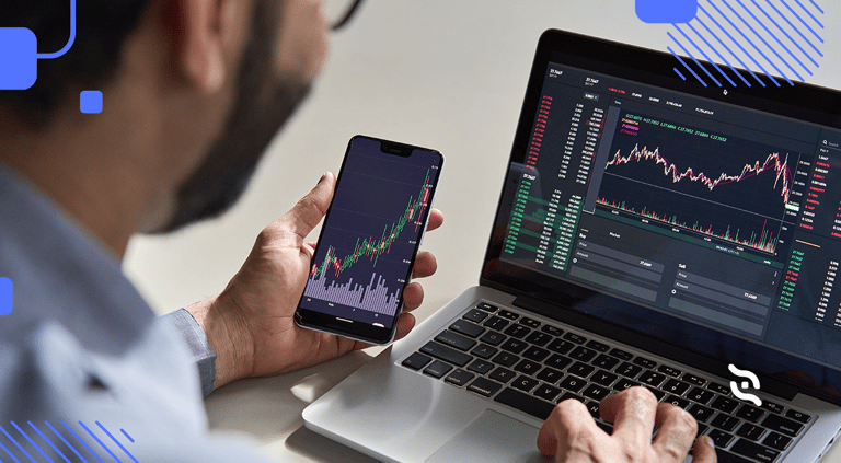 empreendedor com celular e notebook na mão lendo sobre dicas de investimento