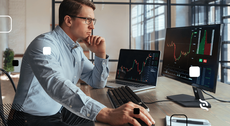 imagem de um homem de cabelos curtos, óculos, sentado e acompanhando as tendências financeiras para 2023 na frente de um notebook